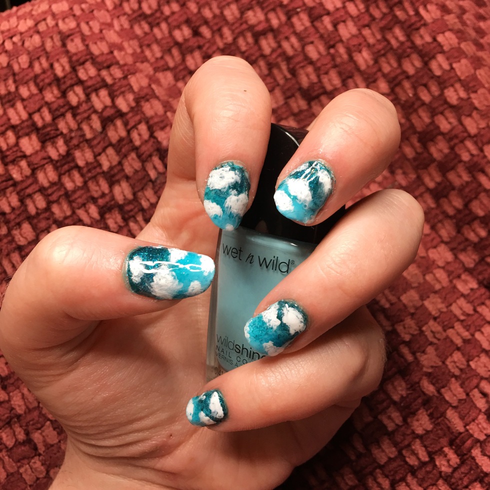 nails painted with a partially cloud nail design with a dark to light blue gradient.