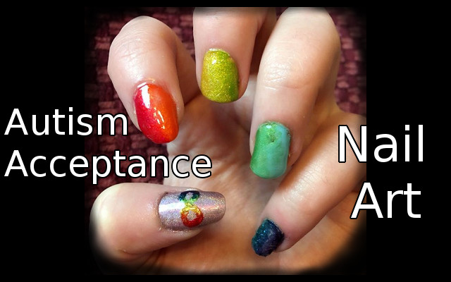 Autism Acceptance Nail art, with a gradient through the color spectrum on finger nails and on the thumb, a lavender holographic polish with a neurodiversity symbol on it.
